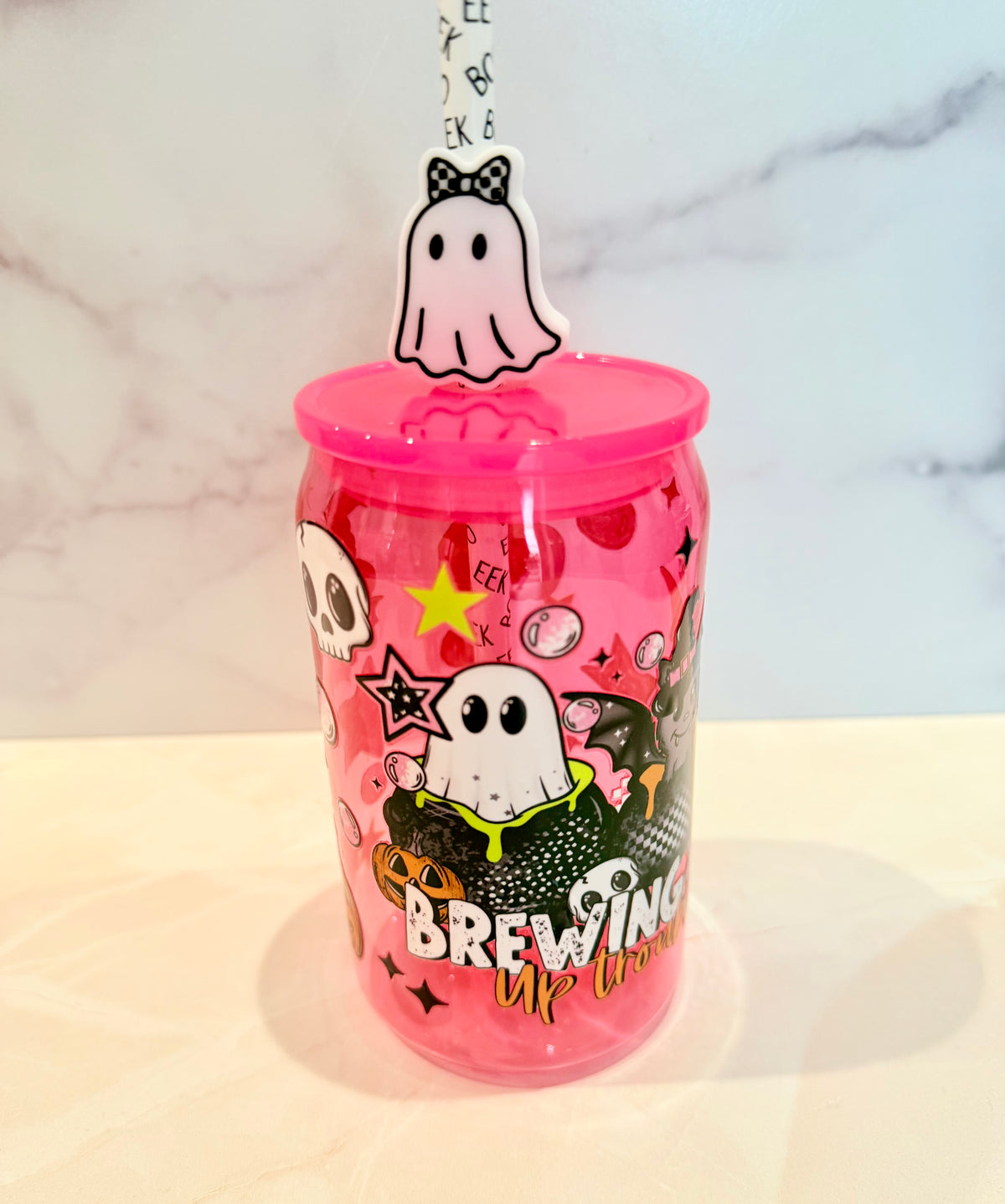 Hot pink Halloween tumbler with ghost charm lid topper and Brewing Up Trouble text, 16oz acrylic cup