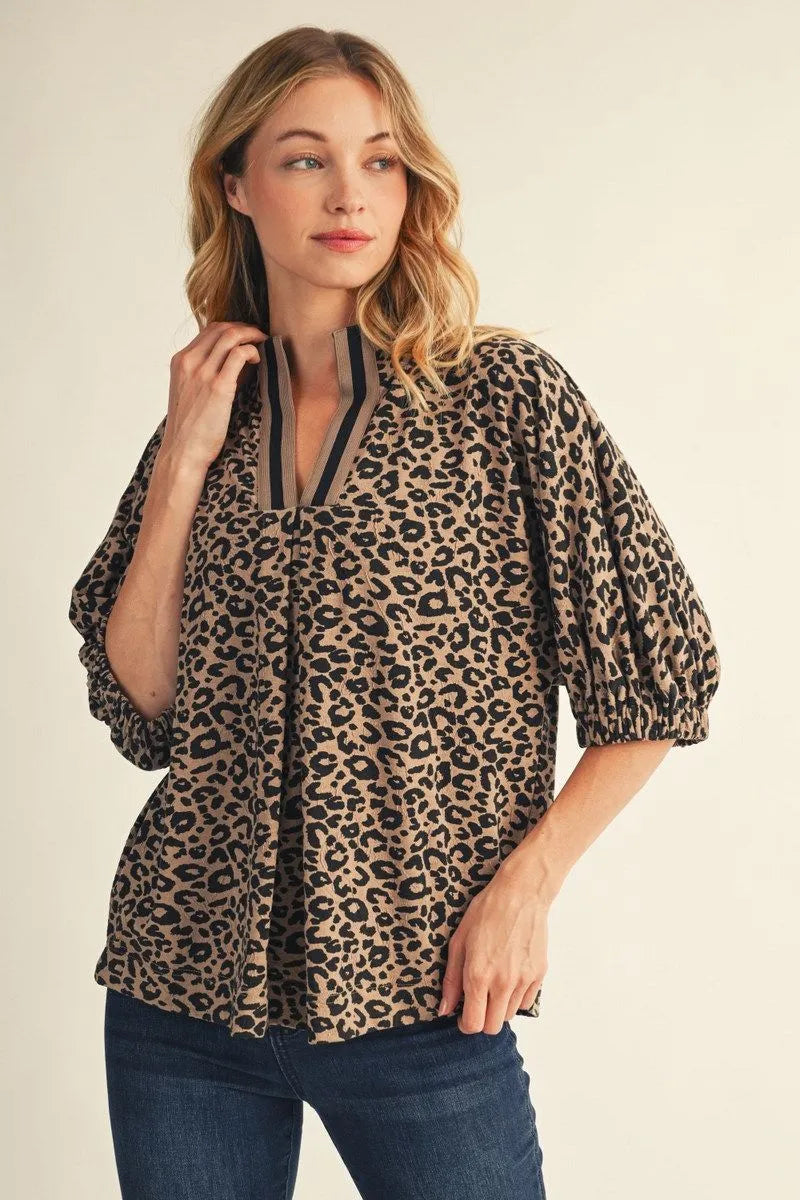 Leopard print women's top with standing collar, contrast ribbed trim and front pleat detail