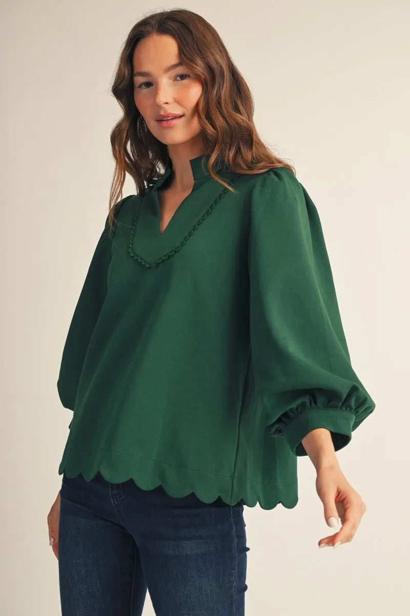 Emerald green scalloped hem top with standing collar and relaxed silhouette