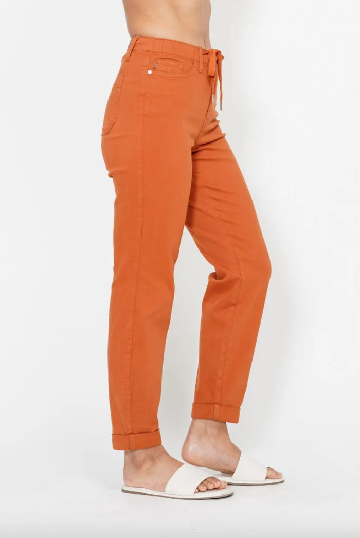 Side view of orange Judy Blue high waist joggers showing the tapered leg and rolled hem