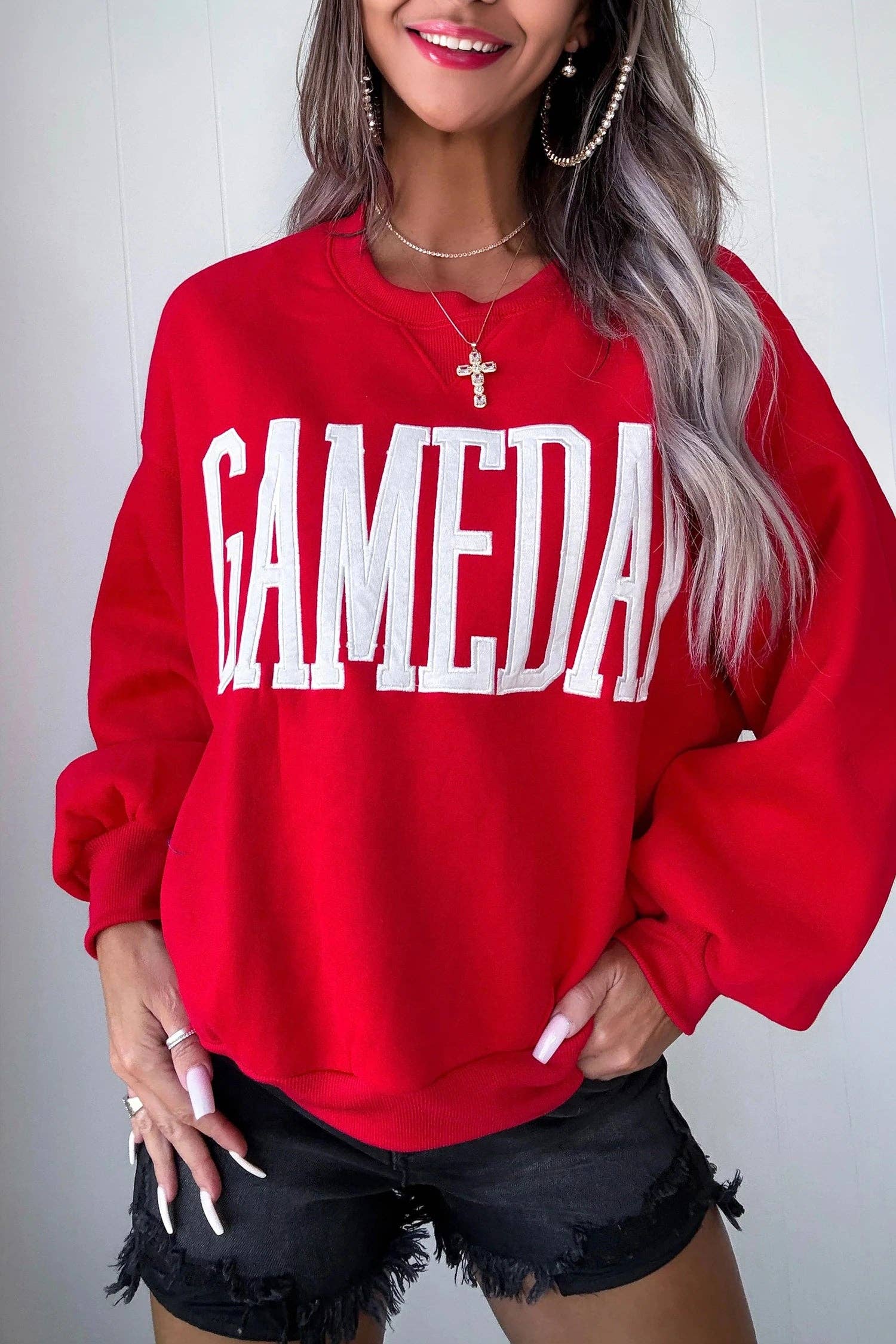 Person wearing a red sweatshirt with 'GAMEDAY' text