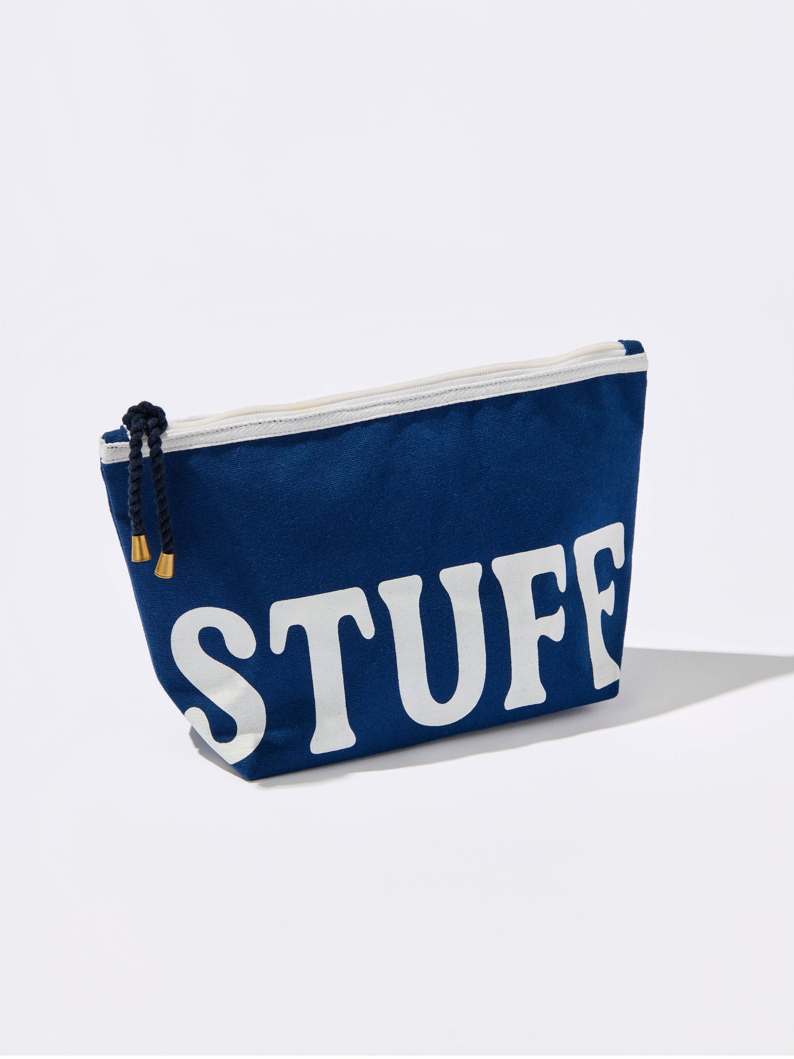 Navy canvas STUFF zip pouch with white lettering and rope zipper pull for organizing makeup, toiletries, travel essentials, and everyday accessories.