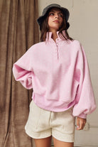 Oversized pink polka dot pullover with ribbed cuffs and snap-up collar for spring fashion.