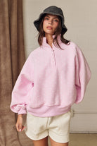 Oversized pink polka dot pullover with ribbed cuffs and snap-up collar for spring fashion.
