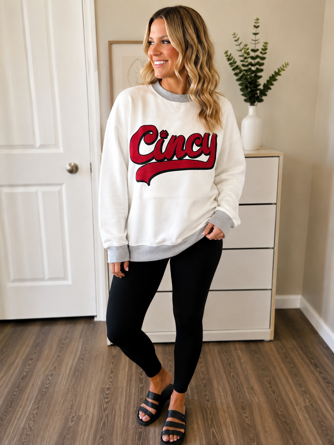 Woman wearing Cincinnati Bearcats reversible mock neck sweatshirt with black leggings for a casual UC game day outfit