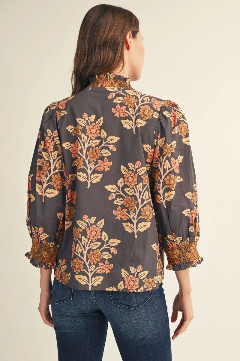 Back of charcoal floral blouse with rust and peach flowers and smocked sleeve cuffs