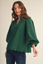 Emerald green scalloped hem top with standing collar and relaxed silhouette