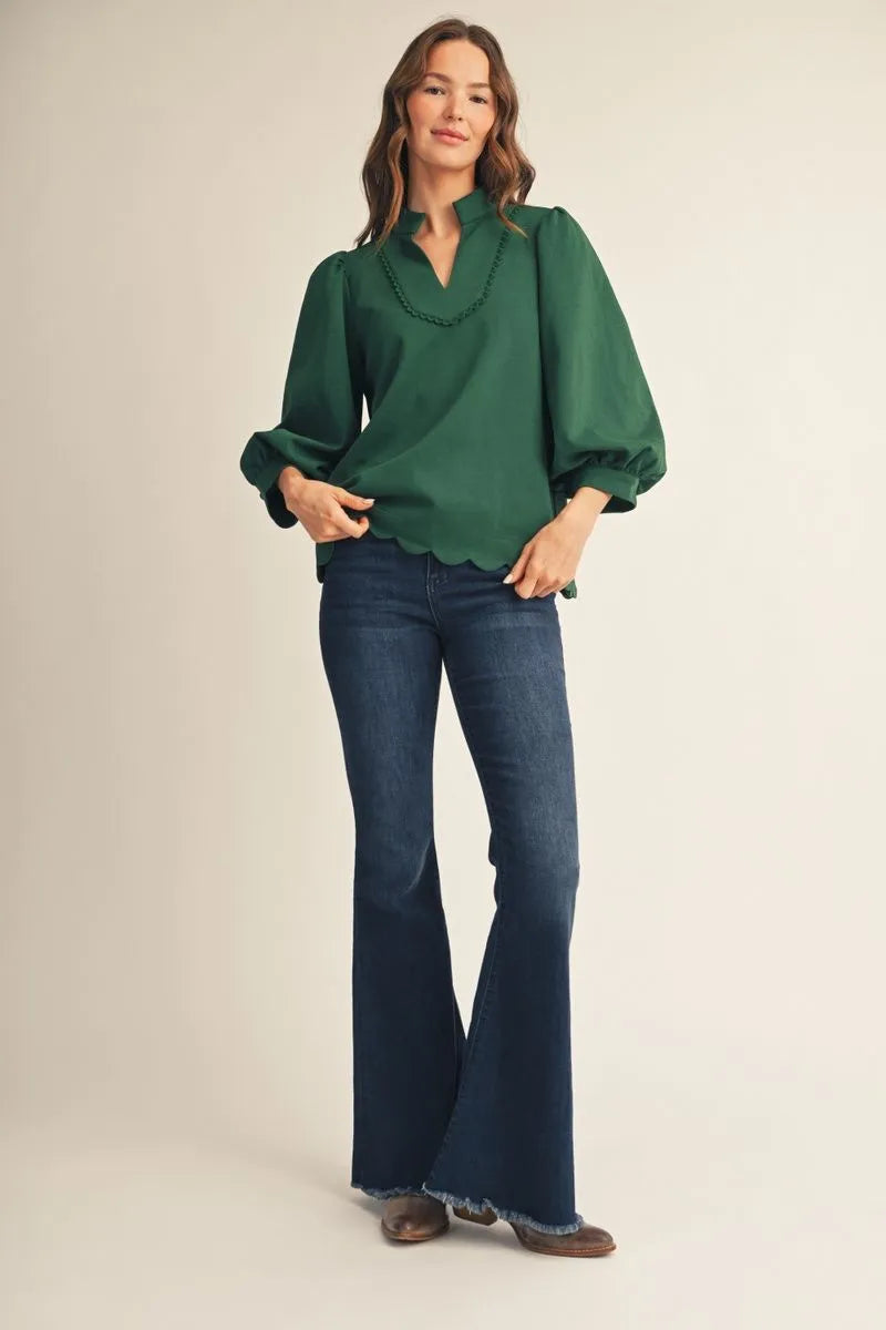 Emerald green scallop trim blouse with 3/4 puff sleeves styled with dark wash flare jeans