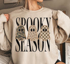 Cream Spooky Season Halloween sweatshirt featuring three embroidered-style ghosts in camouflage, leopard print, and checkered patterns.