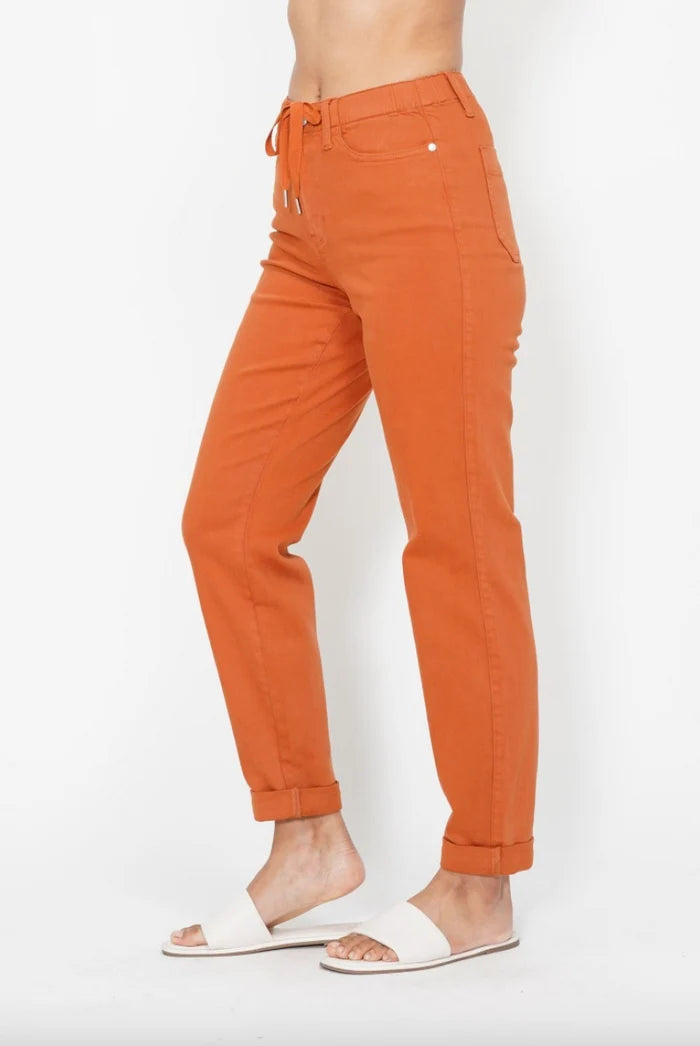Angled front view of Judy Blue orange stretch denim joggers with double cuffs