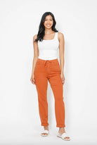 Model wearing Judy Blue orange double cuff joggers with a white tank top and white sandals