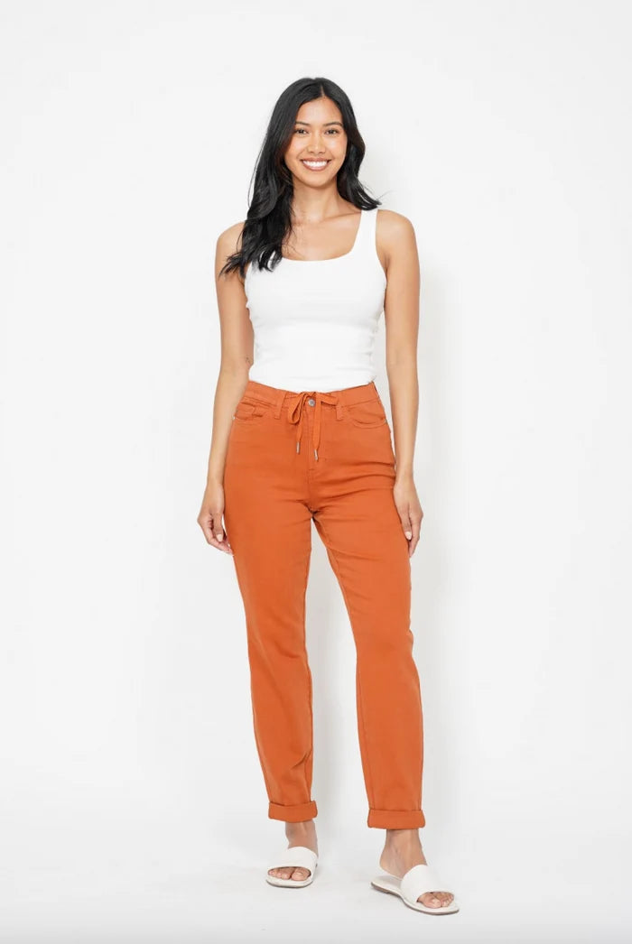 Model wearing Judy Blue orange double cuff joggers with a white tank top and white sandals
