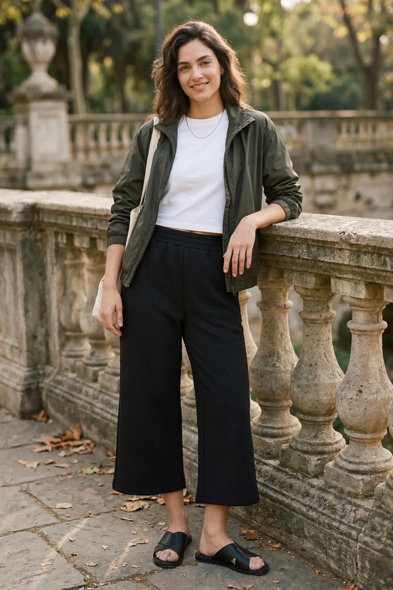 Women’s black textured cropped wide-leg pants featuring a comfortable elastic waistband and relaxed fit. Easy-to-style pants for travel, work, and casual occasions.